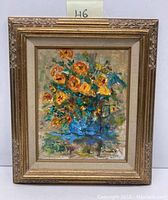 Frontal view of framed signed oil painting on board showing vibrant floral still life inside gold decorative frame.