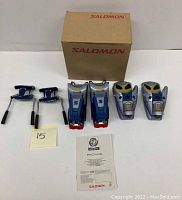 Full set of Salomon 850 S ski bindings including heel and toe bindings, springs, box, and manual laid out on white surface.