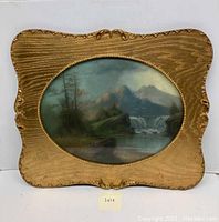 Full view of framed pastel landscape artwork showing waterfall, mountains, trees in a rustic ornate wood frame with an oval cutout.
