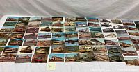 Wide view of 35 vintage railway transportation postcards and lithographs laid out on a flat surface.