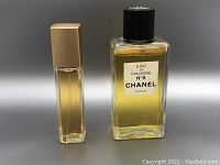 Two vintage perfume bottles, one Chanel No. 5 Eau de Cologne, and one smaller bottle with beige cap.