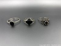 Front view of all three rings in a row showing their black stones and designs.