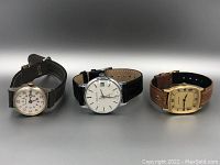 Three vintage wristwatches together showing overall condition and comparative sizes.