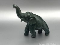 Left side angled view showing the raised trunk and detailed features of the blood stone elephant figurine.