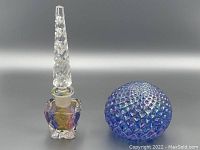 Photo shows the perfume bottle and paperweight side by side on a dark gradient background to highlight iridescent colors.