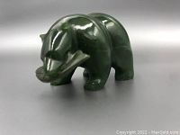 Front-left angled view of the green jade grizzly bear carving, showcasing the bear's face and overall form.