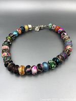 Full view of the Pandora silver necklace laid out in circular form showing all beads and clasp.