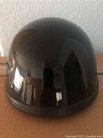 Front view of glossy black half motorcycle helmet showing smooth rounded shell surface.