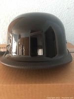 Front view of glossy black half helmet showing smooth rounded surface and short brim