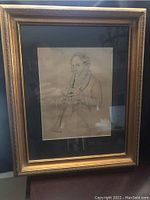 Framed antique print #1 of man playing a woodwind instrument, surrounded by dark blue matting and ornate gold frame.