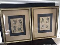 Pair of two gold-toned framed decorative prints with beige and black matting, each containing four detailed black and white profile portraits of men in historic or tribal attire, photographed in natural light showing reflections in glass.