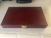 Closed wooden box with brass latch of the firearm cleaning kit