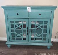 Front view of Bayberry Blue accent chest showing drawers and glass cabinet doors.