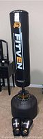 Full view of the Fitven free-standing punching bag and gloves positioned on floor near furniture