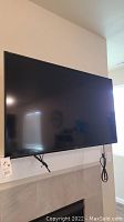 Front view of 50" Vizio TV mounted above fireplace