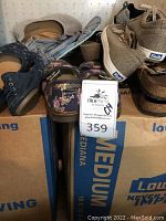 Top view of mixed women's shoes and wedge heels on cardboard box, various styles and brands, close-up of shoe details.