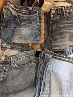 Photo showing folded women's jeans in various light to medium blue denim washes.