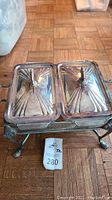 Top view of double buffet chafing dish showing two lids with geometric ridges and knob handles.