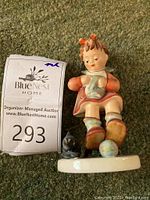 Front view of Hummel figurine 'Mother's Helper' showing girl with cat and yarn ball.