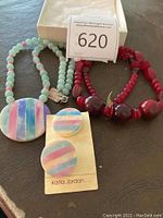 Photo of the lot including two beaded necklaces and a pair of earrings displayed on a surface.