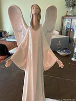 Front image of white glazed NAO by Lladró Christmas Angel with wings and outstretched hands.