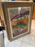 Framed abstract colored chalk artwork leaning against a wall, visible textured frame, and vibrant chalk colors.