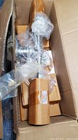 Boxed Murray Feiss VS5102-PW wall sconce wrapped in plastic and cardboard inside a shipping box.