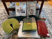 Top view of all items in the lot including packaged linens, umbrella, and neck rest