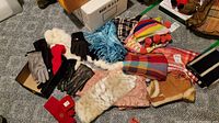 Wide view showing various winter scarves, gloves including leather, knit, and rabbit fur, with knit hats in background