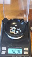 Top view of multiple small calibrated round opal cabochons on a scale showing total weight 4.080 grams (~4.1 carats).