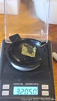 Square cut lemon citrine gemstone on scale showing 32.05 ct weight.