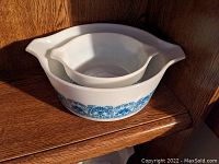 Two Pyrex Horizon Blue casserole dishes nested, showing blue decorative pattern and integrated handles.