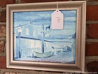 Full view of the framed oil painting depicting a seaside tavern by the dock with a lamp post and boat.