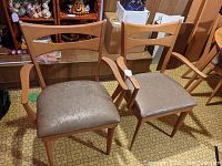 Pair of Heywood Wakefield dining arm chairs with wooden frames and vinyl upholstered seats shown side by side.