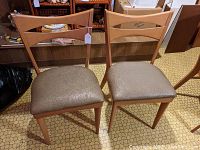 Pair of Heywood Wakefield Encore dining chairs shown together on hexagonal patterned linoleum floor.