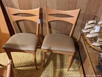 Front view of both Heywood Wakefield dining chairs showing overall styling and finish