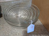 Set of 9 clear glass bowls nested together, showing graduated sizes and nesting capability.