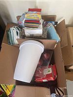 Box containing cleaning sponges, cloths, and white plastic buckets with lids