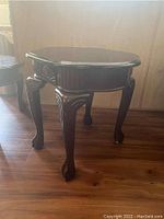 Side angle of the wooden end table highlighting carved legs and decorative apron.