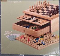 Photo of wooden multi-game set box showing layered boards with chess, dice, playing cards, colorful pegs, and game tools visible.