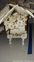 Front view of Capodimonte butterfly barrel showing white flowers and gold accents with blue stones.