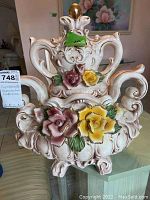Front view of Capodimonte reproduction porcelain centerpiece with colorful roses and scroll designs.