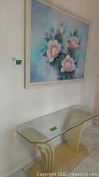 Photo of the pastel flower painting above the cream and glass retro console.