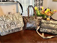 Photo of three water-resistant vegan bags: two Sakroots and one Danica, showing their size and overall print design