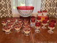 Full set showing punch bowl at center with twelve stemmed punch cups and eight stemmed cocktail/port glasses arranged around it.
