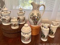 Full set of seven ceramic kitchen containers and jug shown on table.