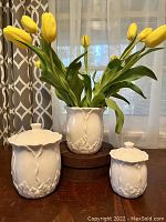 Set of three white ceramic pieces by American Atelier displayed with flowers, showing size and floral texture detail