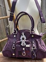 Front view of deep purple GG&L canvas cargo bag with convertible strap, metal GG&L buckle and front zipper pocket