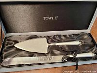 Two Towle cake servers in black box with satin lining, knife and triangular server visible.