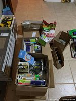Box with fertilizer bag, various electrical supplies and boxes containing small hardware.